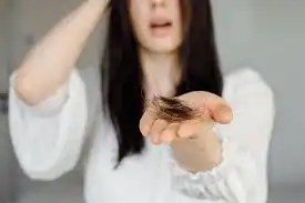 cabelo da mulher caindo em grandes quantidades